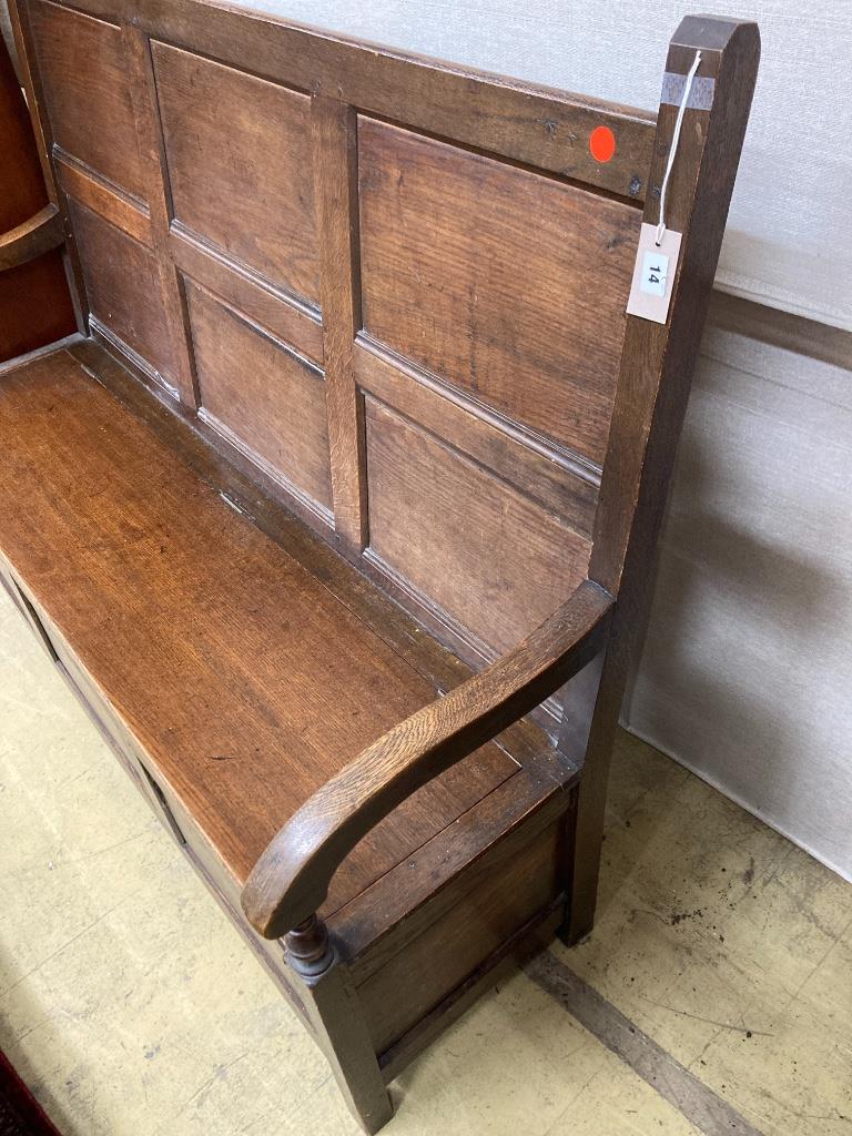 A mid 18th century panelled oak hinged box seat settle, length 148cm, depth 56cm, height 122cm